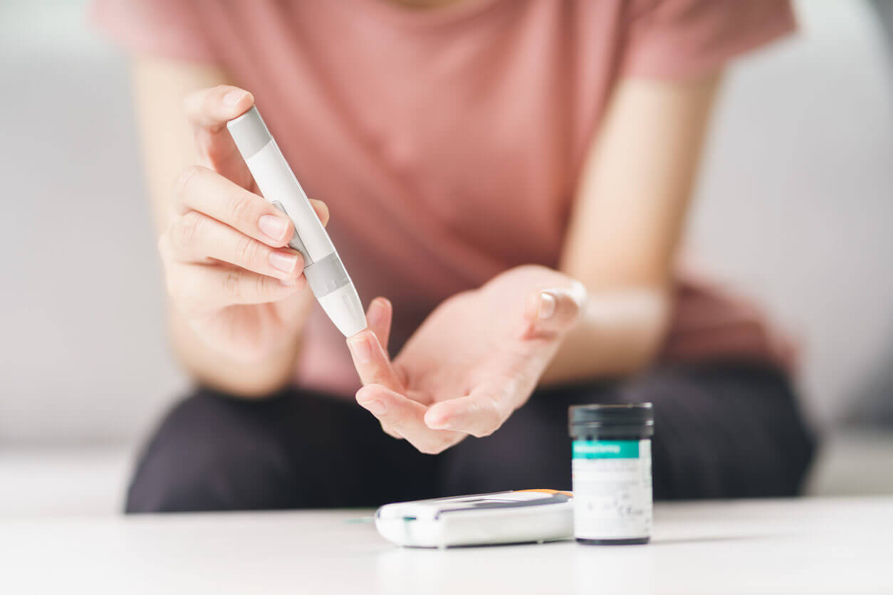 close up of woman with diabetes finger prick device